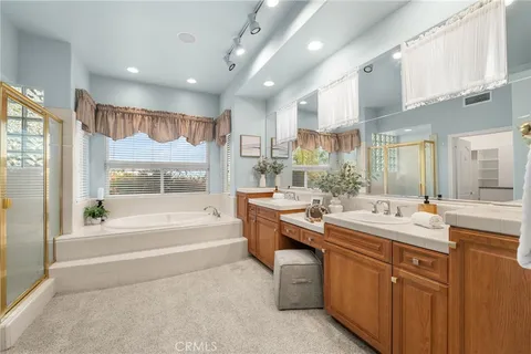 a spacious bathroom with a tub a sink and a large mirror