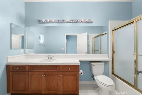 an empty room with a chandelier fan and windows