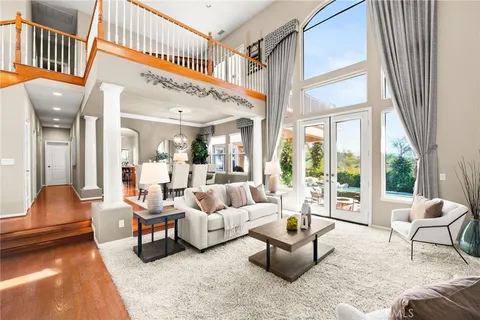 a living room with furniture a chandelier and a dining table