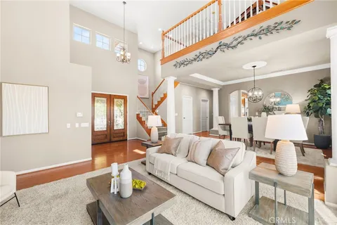 a living room with furniture kitchen view and a large window