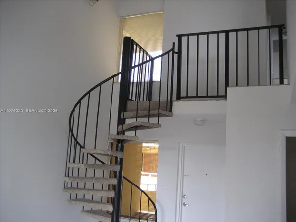 a view of staircase with railing and a window