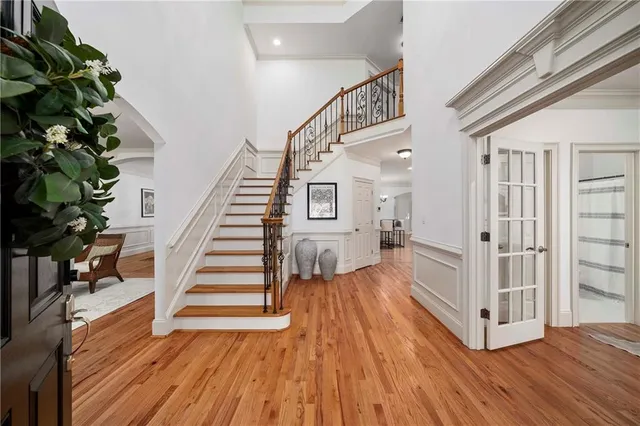 a view of a hallway with wooden floor and stairs