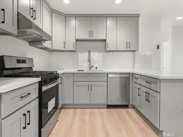 a kitchen with white cabinets stainless steel appliances and sink