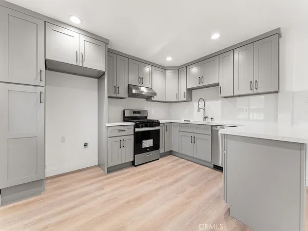 a kitchen with stainless steel appliances granite countertop a refrigerator sink and stove