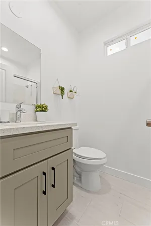 a bathroom with a granite countertop toilet sink and mirror