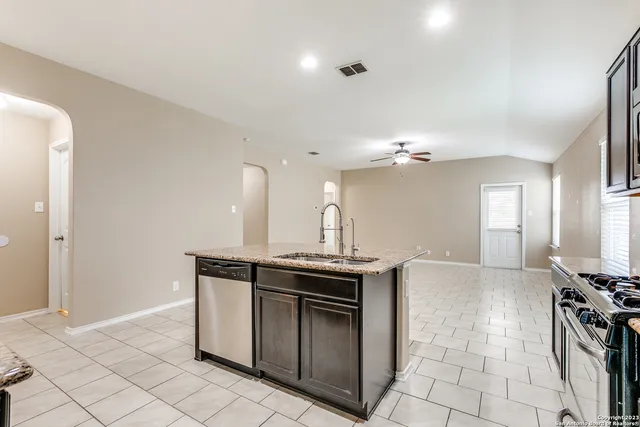 a kitchen with stainless steel appliances granite countertop a sink and a stove