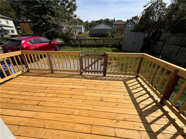 a view of swimming pool with seating space and trees in the background