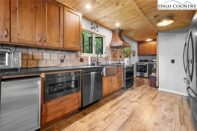 a kitchen with stainless steel appliances granite countertop a stove a sink dishwasher and a refrigerator