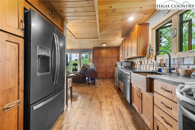 a kitchen with sink a refrigerator and wooden floor