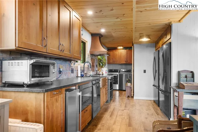 a kitchen with stainless steel appliances granite countertop a refrigerator a stove and a sink