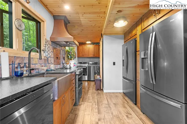 a kitchen with stainless steel appliances a refrigerator a sink a stove and cabinets