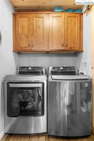 a utility room with wooden floor washer and dryer