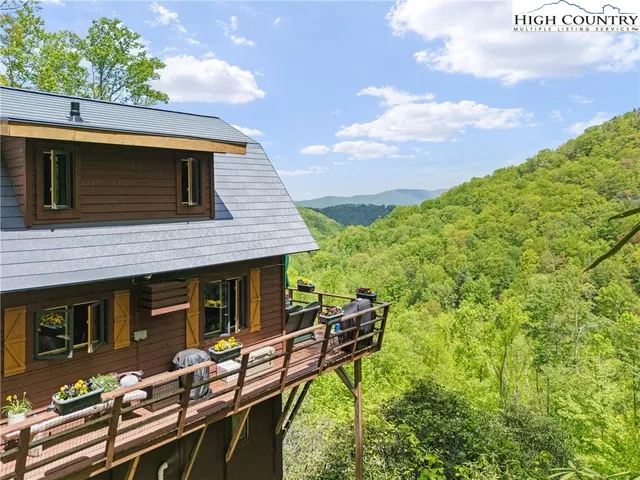 a backyard of a house with wooden floor barbeque oven and outdoor seating