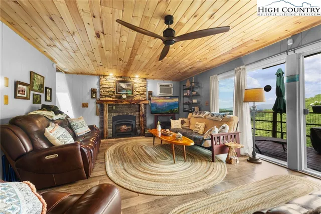a view of a livingroom with furniture a fireplace a chandelier and wooden floor