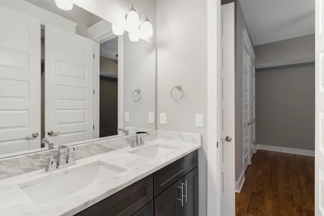 a bathroom with a double vanity sink a mirror and a shower