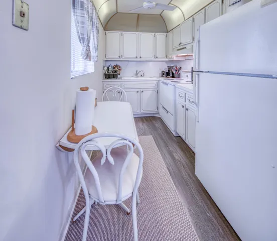 a kitchen with cabinets a sink and white appliances