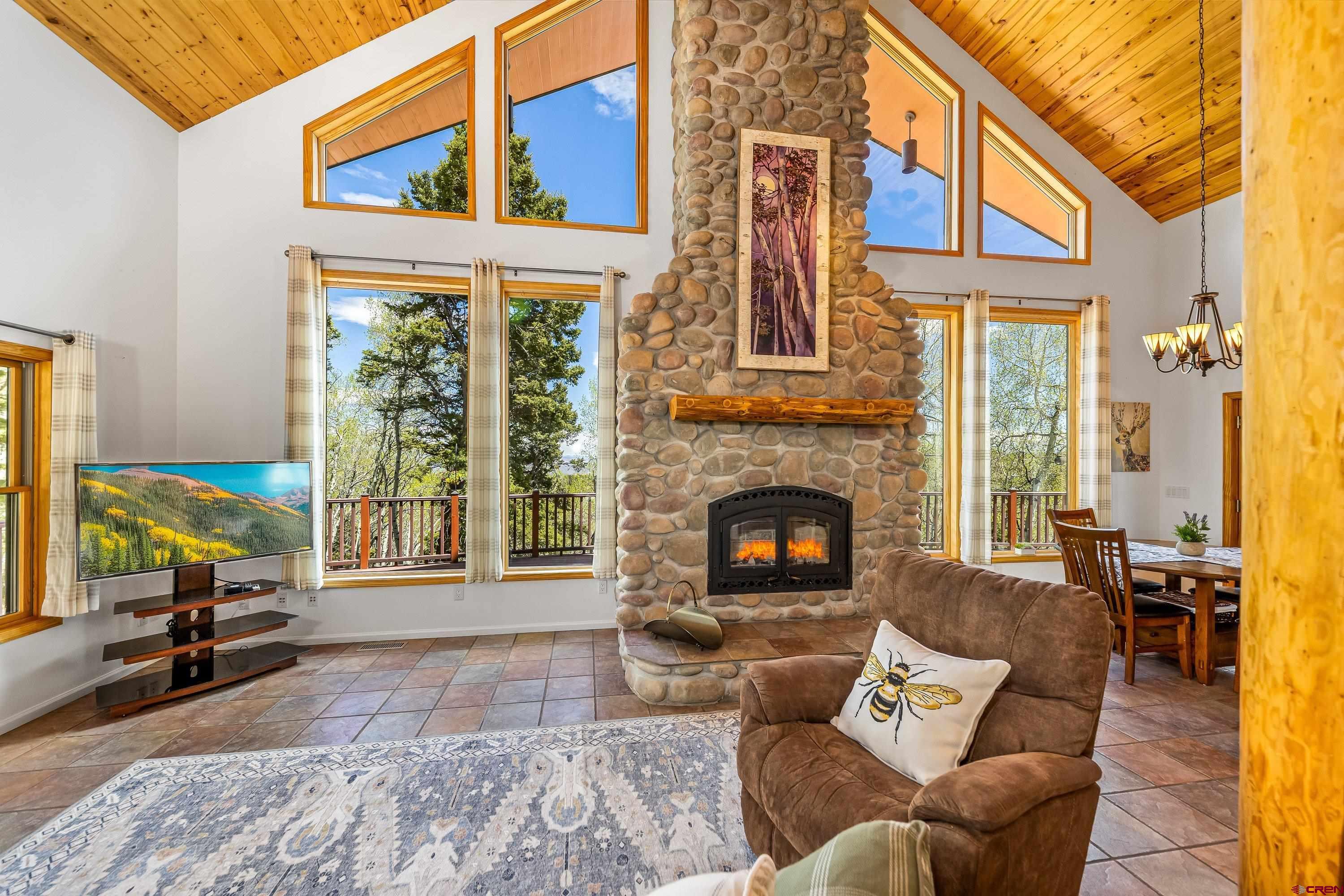 180 Ridge Road Cimarron, CO 81220 - Photo 12 of 42 a living room with furniture a fireplace and large windows