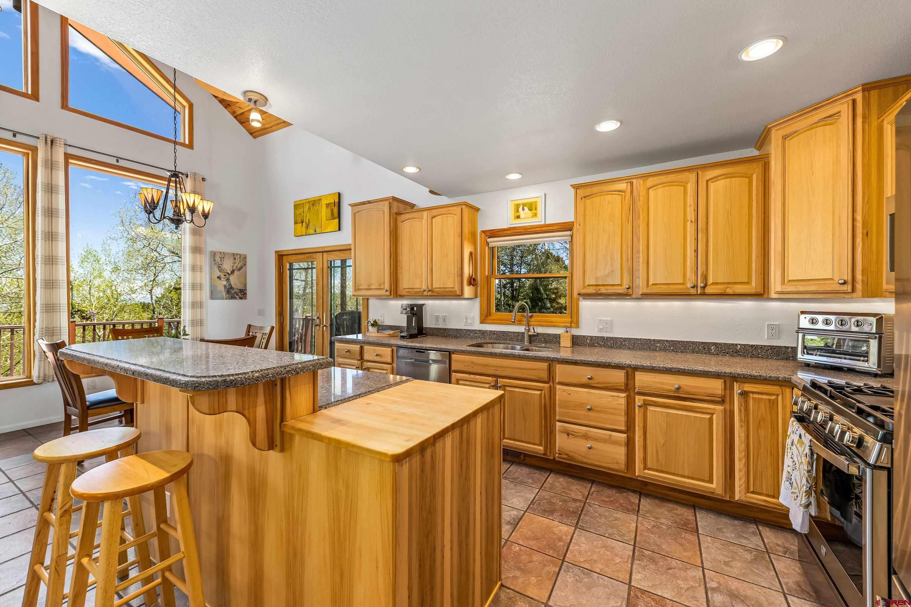 180 Ridge Road Cimarron, CO 81220 - Photo 15 of 42 a kitchen with stainless steel appliances a table chairs sink and cabinets