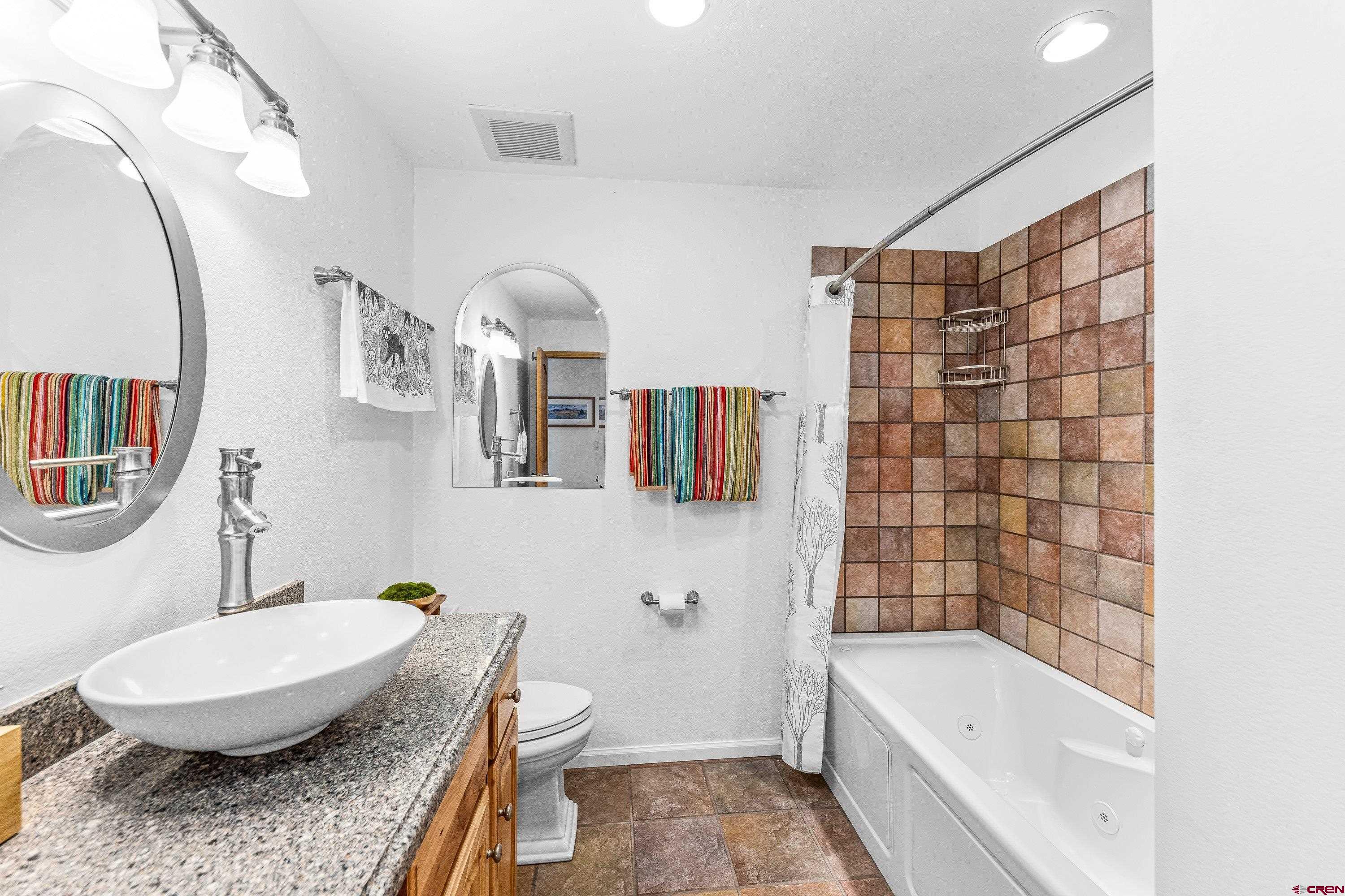 180 Ridge Road Cimarron, CO 81220 - Photo 21 of 42 a bathroom with a granite countertop sink a toilet a mirror and bathtub