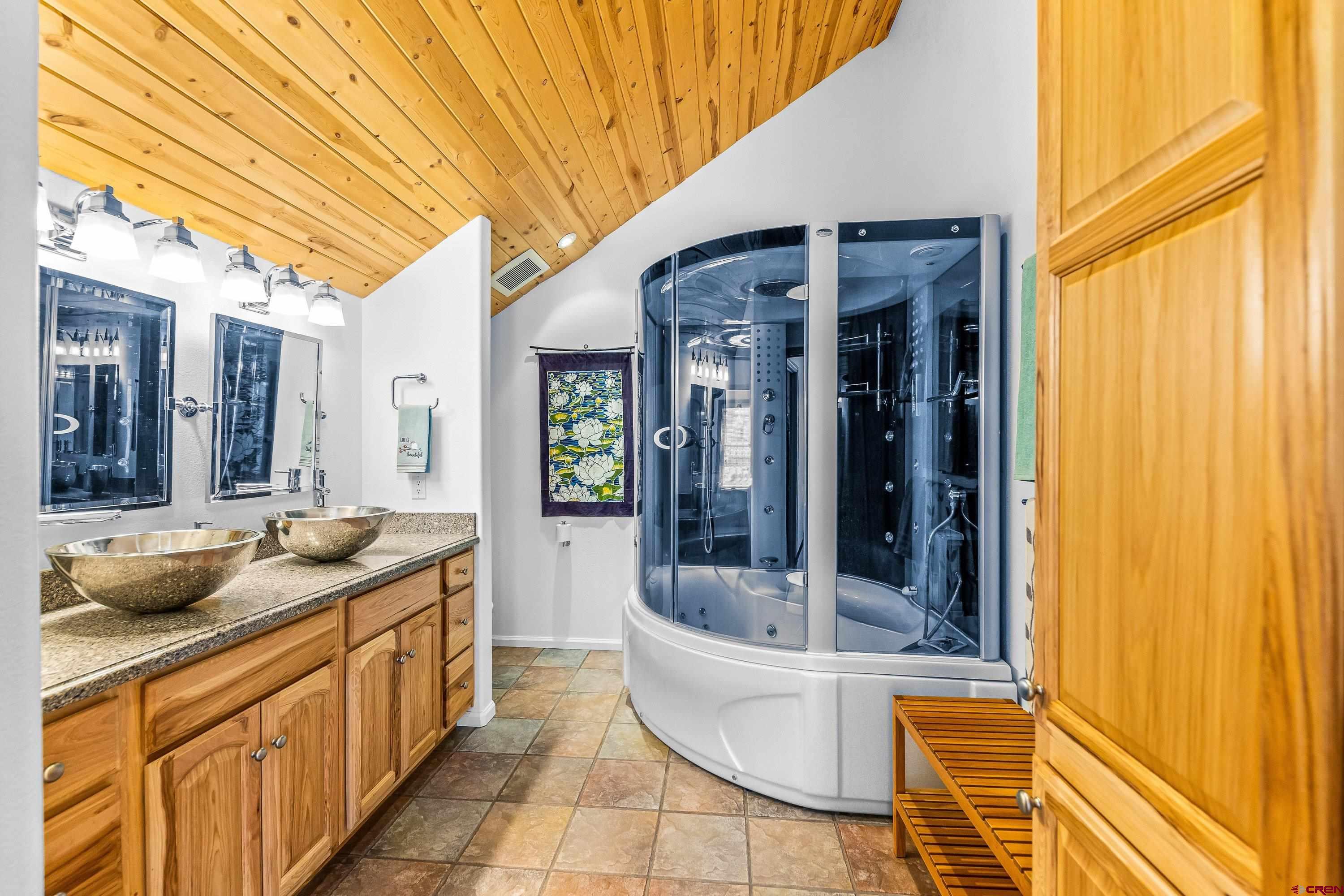 180 Ridge Road Cimarron, CO 81220 - Photo 25 of 42 a bathroom with a granite countertop sink and mirror