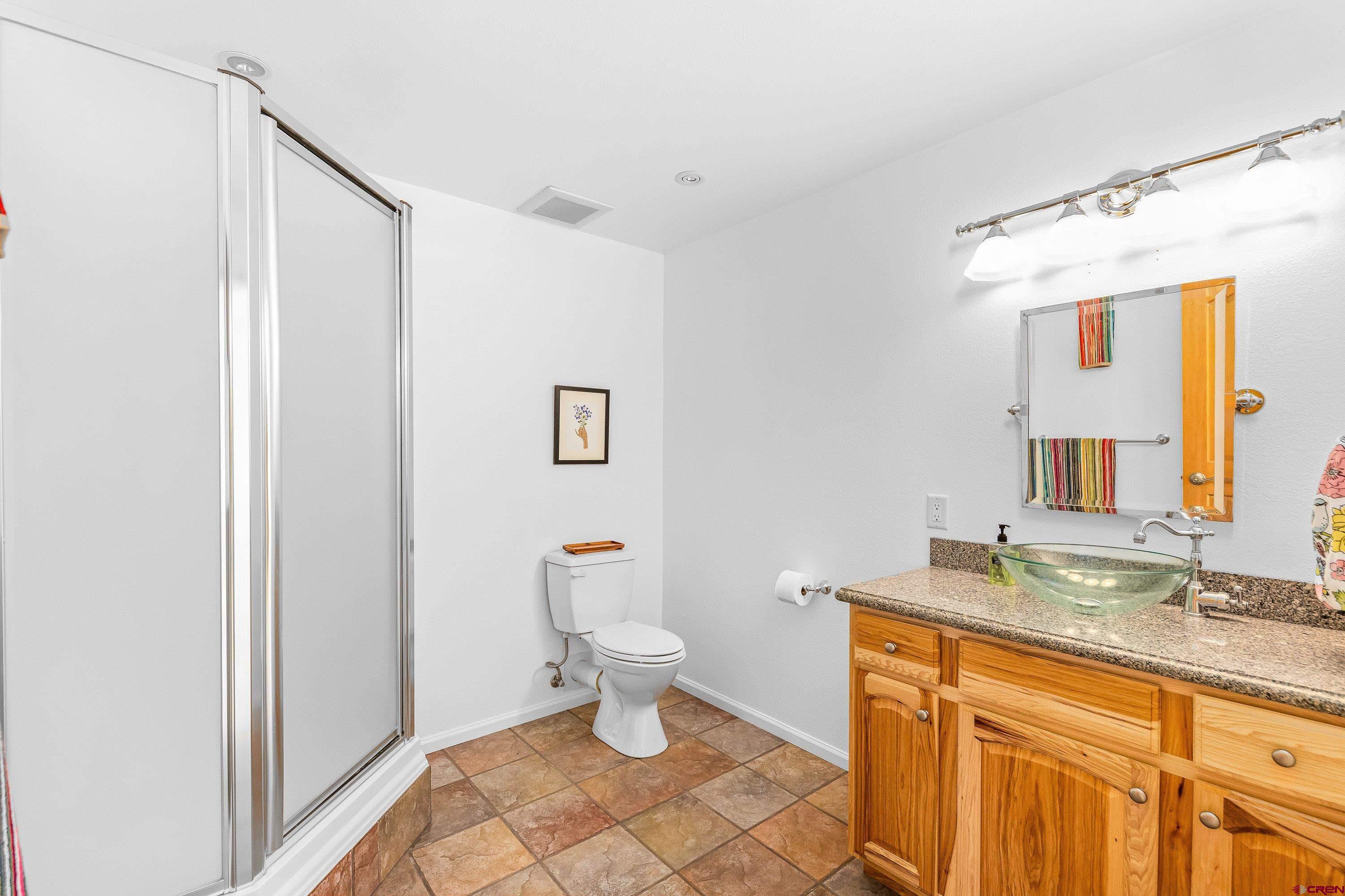 180 Ridge Road Cimarron, CO 81220 - Photo 32 of 42 a bathroom with a granite countertop sink toilet and shower