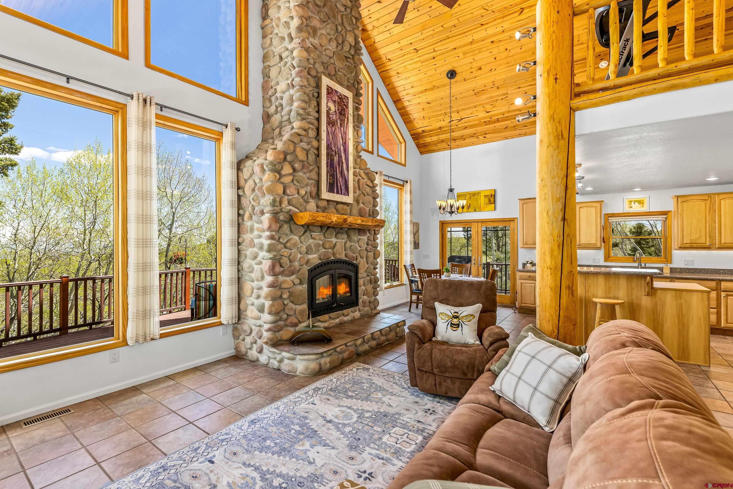 180 Ridge Road Cimarron, CO 81220 - Photo 10 of 42 a living room with furniture a fireplace and a floor to ceiling window