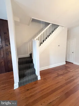 a empty room with hard wood floors ceiling fan and window