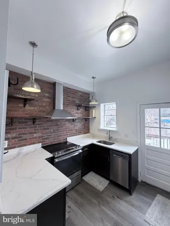 a kitchen with stainless steel appliances granite countertop a sink a stove and a wooden floors