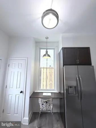 a kitchen with stainless steel appliances a refrigerator and a hard wood floor