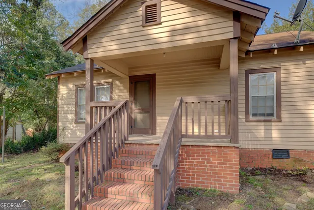 a view of a house with wooden walls and a porch