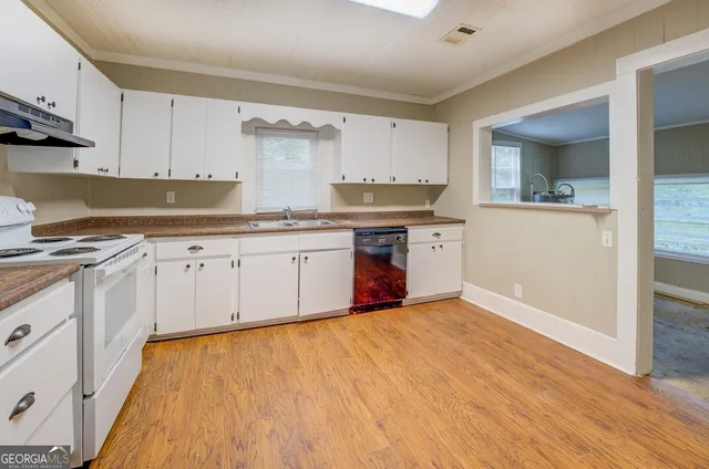 a kitchen with stainless steel appliances granite countertop a stove and white cabinets