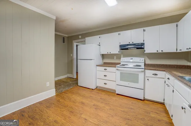 a kitchen with white cabinets and white appliances