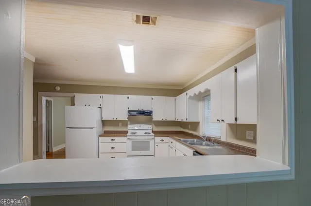 a kitchen with stainless steel appliances granite countertop a refrigerator sink and white cabinets