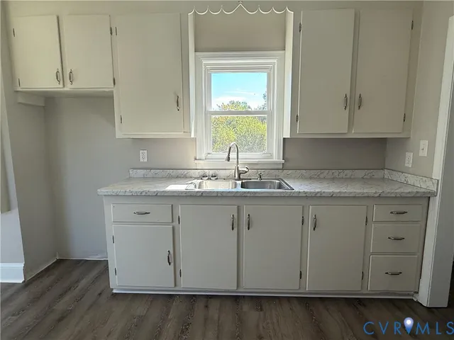 a sink with granite countertop white cabinets and a sink