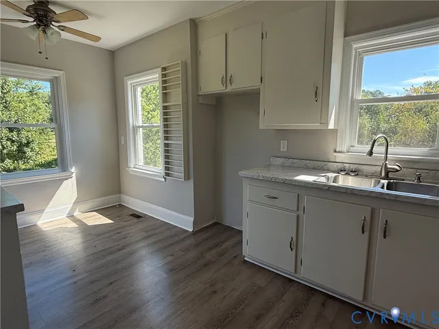 a kitchen with granite countertop a sink cabinets stainless steel appliances and a window