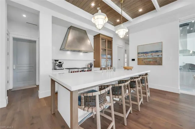 a kitchen with stainless steel appliances a stove a sink dishwasher and white cabinets with wooden floor