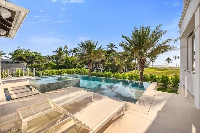 a living room with furniture large window and wooden floor