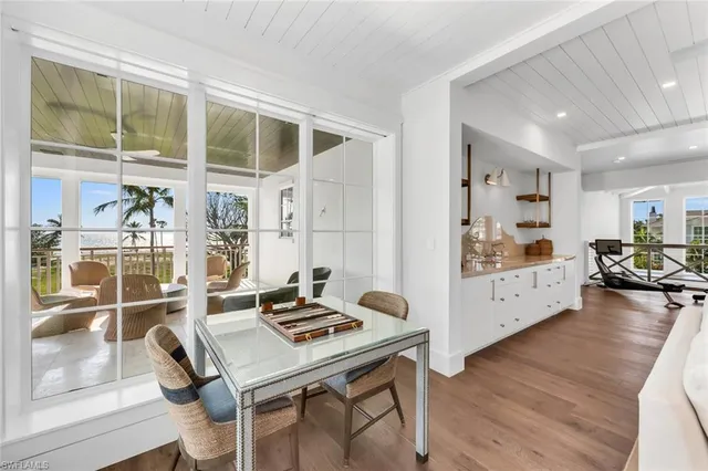 a bedroom with a bed a mirror and a large window