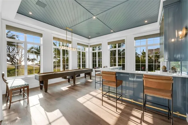a dining room with wooden floor a chandelier a wooden table and chairs