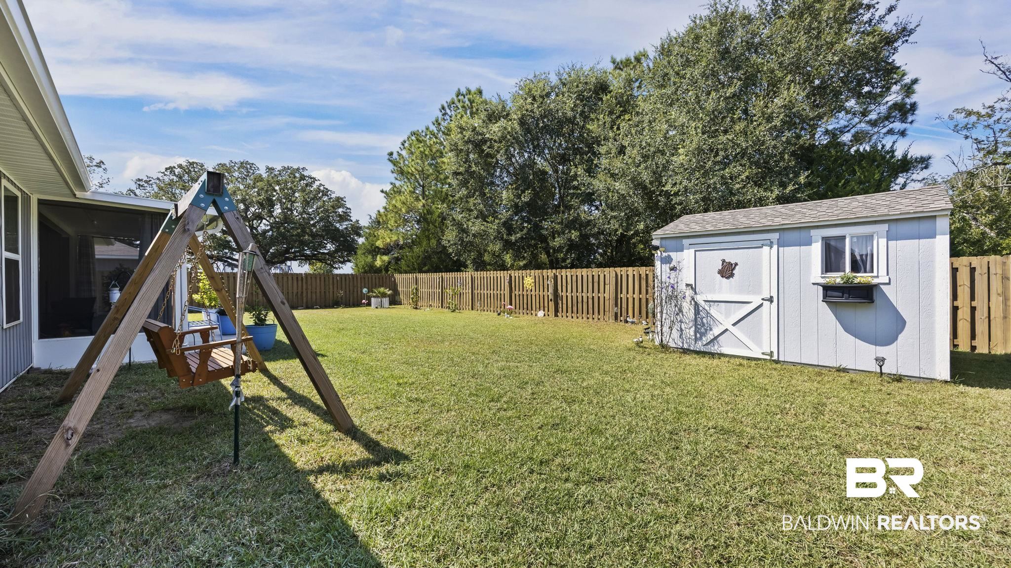 349 Hartenstein Road Foley, AL 36535 - Photo 11 of 32 Fenced backyard with a shed and a sunroom