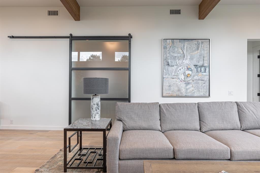 4202 Bonham Street Dallas, TX 75229 - Photo 29 of 32 Living room with beamed ceiling, wood finished floors, and a barn door
