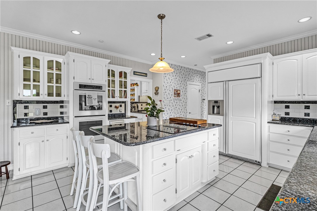 10299 Paddy Hamilton Road Belton, TX 76513 - Photo 20 of 46 a kitchen with stainless steel appliances kitchen island granite countertop a stove a sink and a refrigerator