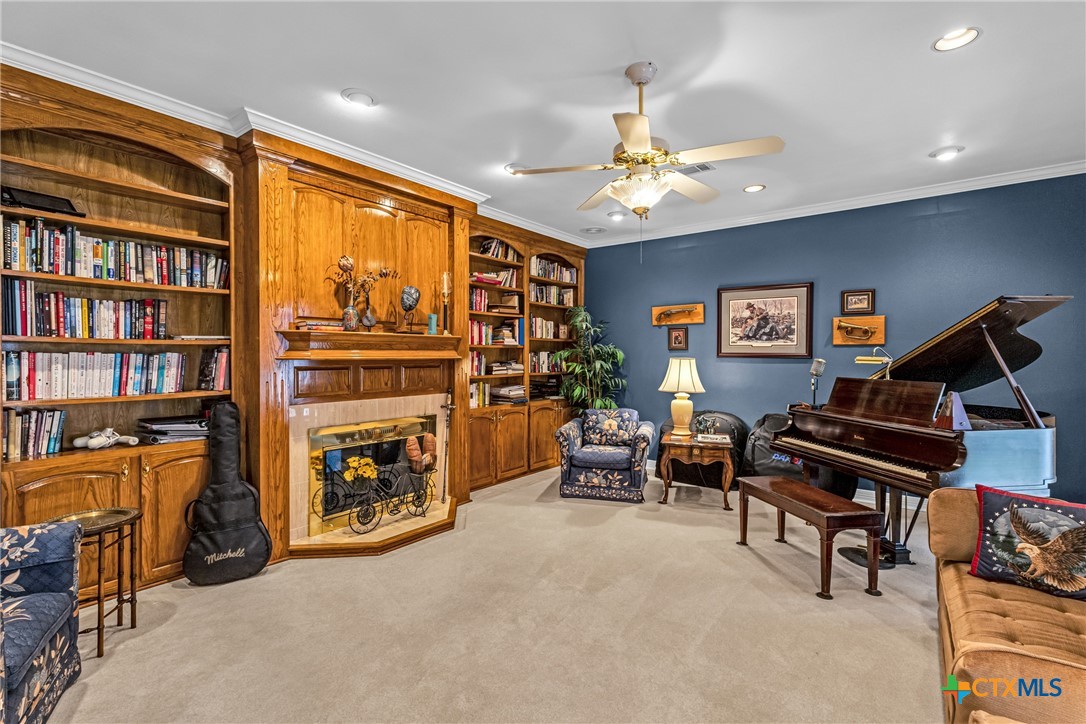 10299 Paddy Hamilton Road Belton, TX 76513 - Photo 27 of 46 a living room with furniture a bookshelf and a flat screen tv