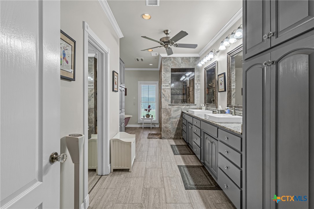 10299 Paddy Hamilton Road Belton, TX 76513 - Photo 35 of 46 a bathroom with a double vanity sink a mirror and a shower