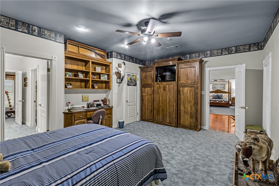 10299 Paddy Hamilton Road Belton, TX 76513 - Photo 38 of 46 a bedroom with a bed and a chandelier