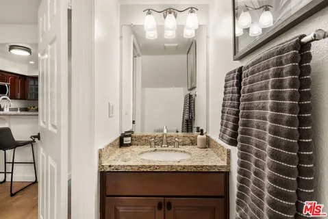 a bathroom with a granite countertop sink and a mirror