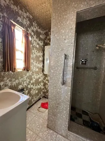 a bathroom with a granite countertop sink a toilet and shower