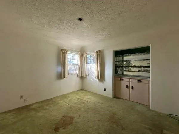 a view of a kitchen with white cabinets and wooden floor
