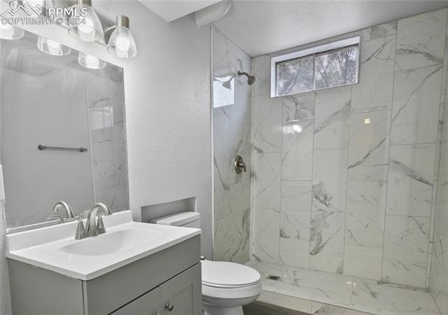 537 Yellowstone Road Colorado Springs, CO 80910 - Photo 7 of 7 Bathroom with tiled shower, vanity, and toilet