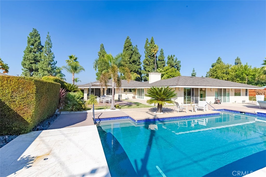 a view of a swimming pool with lounge chairs in patio